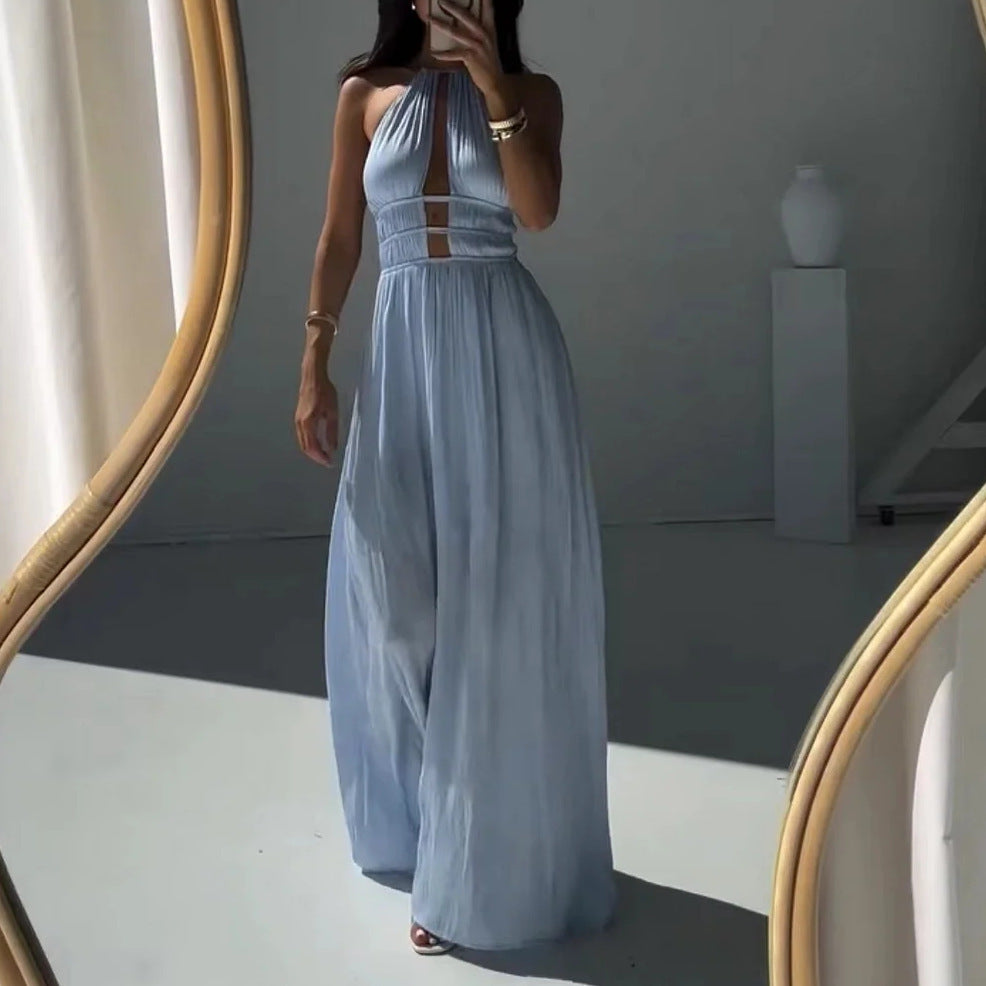 Woman in a long light blue halter maxi dress standing in front of a mirror.