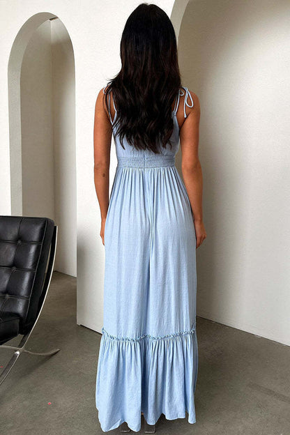 Woman wearing a light blue maxi boho dress with cut-out design and high slit, standing in a room.