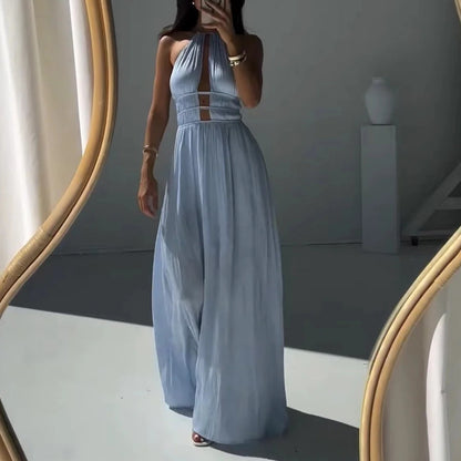 Woman in a long light blue halter maxi dress standing in front of a mirror.