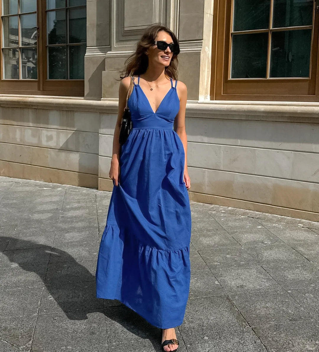 Woman in a blue boho maxi dress standing in front of a building