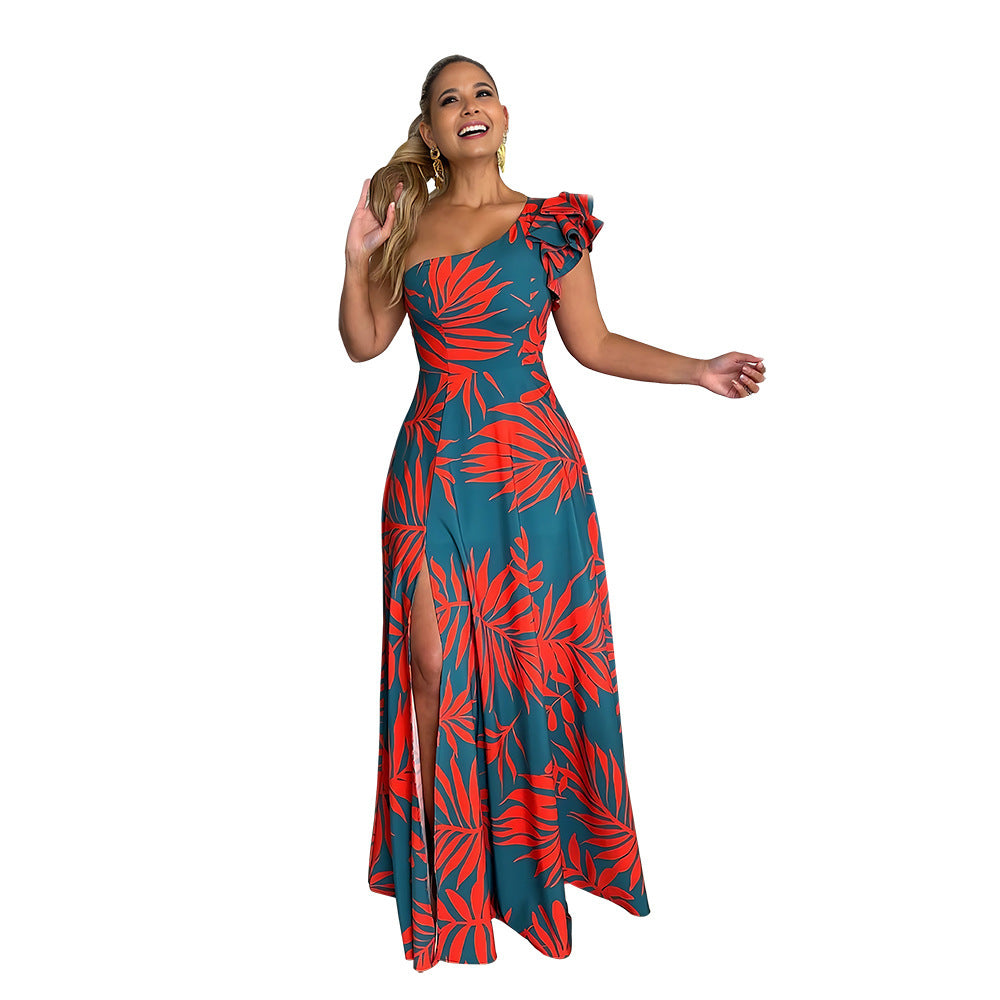 Woman in a red and teal floral dress standing in a white background.
